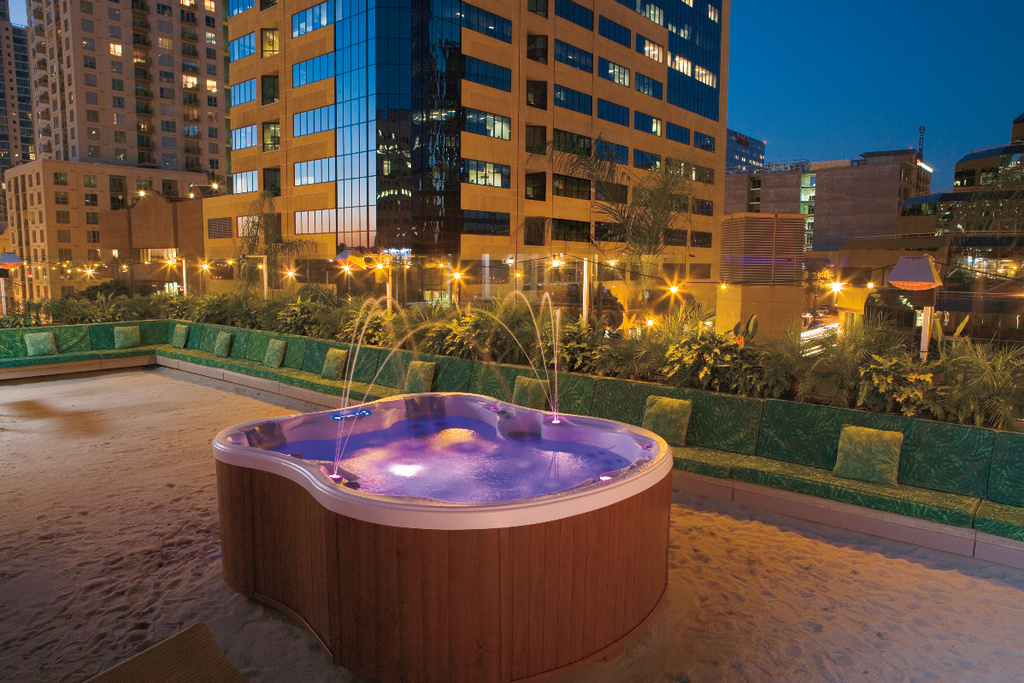 Hot tub on a deck with tall city buildings behind